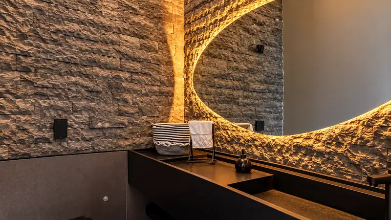 Lavabo com parede de pedra filetada iluminada